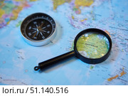 The magnifying glass is located on the world map and magnifies the country of Australia. There's a compass next to it. Concept of travel in the selected country. Стоковое фото, фотограф Наталия Кирсанова / Фотобанк Лори