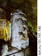 Dark cave view from inside with a lumen. Stalactites and stalagmites inside the stone grotto. Colorful stones in the cave. Lighting electricity beauty of the cave. (2019 год). Стоковое фото, фотограф Наталия Кирсанова / Фотобанк Лори