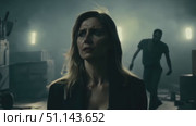 A woman walks cautiously through a dark, eerie industrial setting filled with shadows. Стоковое AI-видео, аниматор Данила Большаков / Фотобанк Лори