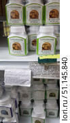Store shelves with jars of garlic-based dietary supplement — Garlic Capsule. The product is produced under the Thanyaporn Herbs brand, each jar contains 100 capsules. The packaging is white with a green label depicting garlic heads. Under the product on the shelf there is a description in Russian, which indicates the properties of the drug: normalization of blood pressure, antiviral, anti-inflammatory and antioxidant action, strengthening the immune system, liver protection and reducing the risk of cardiovascular diseases. Contraindications are also indicated: pregnancy, breastfeeding, kidney and pancreatic diseases. Additionally, there is a handwritten sign with the explanation "Garlic for normalizing blood pressure, anti-inflammatory, vitamin, anti-cold remedy." (2018 год). Редакционное фото, фотограф Анна Кривицкая / Фотобанк Лори