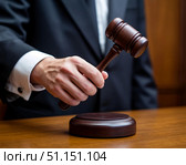 Рука судьи с судейским молотком перед вынесением вердикта. Стоковое AI-изображение, AI-художник Руслан Лесков / Фотобанк Лори