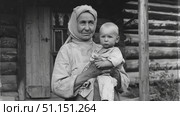 Деревенская бабушка держит малыша-внука на руках. Ретро. A village grandmother holds her baby grandson in her arms. Retro. Стоковое AI-изображение, AI-художник Смирнова Светлана / Фотобанк Лори
