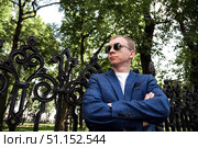 Thinking Man in a Blue Blazer Rests at the Wrought Iron Fence in Central Park. Стоковое фото, фотограф Aleksandr Golubev / Фотобанк Лори