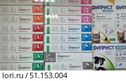Veterinary pharmacy display cases with antiparasitic drugs for pets. In the foreground are packages of Selafort drops in different dosages — from 15 mg/0.25 ml to 240 mg/2 ml, designed for cats and dogs of different weights. The packages are color-coded for easy selection of the drug based on the animal's weight. Also visible on the display case are boxes of Fiprist Combo for cats, ferrets and dogs. The drugs are intended for external use and protection against fleas, ticks, lice and other ectoparasites. The photo is taken close-up, with clearly distinguishable inscriptions on the packages, which makes it suitable for use in medical and pet product catalogs, as well as in materials on veterinary pharmacology. Редакционное фото, фотограф Анна Кривицкая / Фотобанк Лори