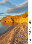 Sunset landscape of Baikal Lake on August. View of pebble beach of Small Sea and rocky shores of Olkhon Island on quiet sunny evening. Picturesque landscape. Natural background. Summer travels. Стоковое фото, фотограф Виктория Катьянова / Фотобанк Лори
