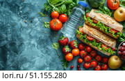 Top view lunch box with sandwiches, fruits and vegetables, water bottle on pastel blue isolated background, with copy-space available for text or promotional content. Стоковое AI-изображение, AI-художник Ирина Михайличенко / Фотобанк Лори