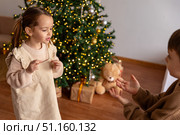 Happy little children, boy and girl holding hands, having fun and dancing near decorated Christmas tree in the morning. Merry Christmas and Happy New year winter holidays. High quality photo. Стоковое фото, фотограф Ирина Михайличенко / Фотобанк Лори