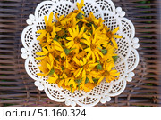 Yellow Jerusalem artichoke flowers are collected in a white lacy vase, standing on a wicker surface for drying. Стоковое фото, фотограф Коханова Наталья / Фотобанк Лори