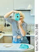 A housewife girl in the kitchen shows a thin bread of a strange blue color. The concept of spoiled or damaged products. Стоковое фото, фотограф Наталия Кирсанова / Фотобанк Лори