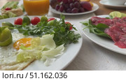 Setting of breakfast includes coffee, fresh orange juice, eggs on table in hotel restaurant Breakfast with coffee surrounded by various food Breakfast Buffet Concept, Breakfast Time in Luxury Hotel. Стоковое видео, видеограф Zita Khasanova / Фотобанк Лори