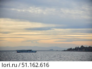 ISTANBUL, TURKEY - NOVEMBER 23, 2021: The Bosphorus Strait. Pleasure boat at sunset. Редакционное фото, фотограф Наталия Кирсанова / Фотобанк Лори