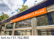 Walthamstow Queens Road station sign, London Overground branding. London, UK, 23 June 2024. Редакционное фото, фотограф Zydrius Tartenis / Фотобанк Лори