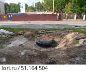 Колодец с люком, обмазанный битумом, в земле летом. Редакционное фото, фотограф Клавдия Васильева / Фотобанк Лори
