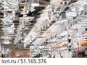 An array of stylish lighting fixtures hangs elegantly from the ceiling of a modern shop. Different types of lamps, sconces, and chandeliers are showcased, highlighting innovative designs. Стоковое фото, фотограф Владимир Разгуляев / Фотобанк Лори