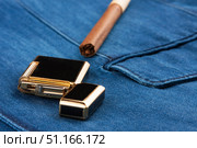 Cigar and lighter lying on a blue denim jacket. Стоковое фото, фотограф Александр Собко / Фотобанк Лори