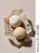 Coconut candy spheres with contrasting texturesone rolled in fine shredded coconut, another in larger flakespositioned on crinkled parchment over neutral background. Стоковое AI-изображение, AI-художник Юрий Поздников / Фотобанк Лори