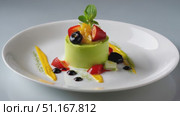 Green tea mousse gleaming with vibrant color, topped by mixed berries and citrus, resting on pristine white backdrop. Стоковое AI-видео, аниматор Юрий Поздников / Фотобанк Лори