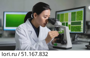 Laboratory technician adjusts microscope focus while examining green algae sample, with computer displaying microscopic view on screen in background. Стоковое AI-видео, аниматор Юрий Поздников / Фотобанк Лори