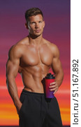 Muscular sportsman gripping protein shaker, standing against sunset sky, revealing athletic build and fitness commitment. Стоковое AI-видео, аниматор Юрий Поздников / Фотобанк Лори