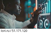 A person engages with a digital data interface, analyzing metrics and graphs in a sleek office setting. Стоковое AI-видео, аниматор Данила Большаков / Фотобанк Лори