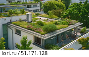 A beautifully designed green roof features various plants and landscaping, enhancing urban sustainability efforts. Стоковое AI-видео, аниматор Данила Большаков / Фотобанк Лори