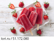 Berry juice popsicles in a plate on a white wooden table with fresh berries. Bright Ice pops with mint leaves and raspberries. Gut-health red pink berry popsicles. Inviting summer scene. Frozen treats. Стоковое AI-изображение, AI-художник Марина Демидюк / Фотобанк Лори