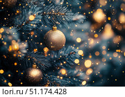 Glimmering Gold Ornaments on a Christmas Tree Illuminated by Soft Lights During the Holiday Season. Стоковое AI-изображение, AI-художник Юлия Гапеенко / Фотобанк Лори