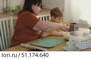 Grandma teaching grandson to make pizza dough. Happy Caucasian granny and grandchild making pizza in kitchen. Cute boy cooking together with grandmother. Family leisure. Multi generation family video. Стоковое видео, видеограф Марина Демидюк / Фотобанк Лори