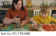 Grandma teaching grandson to make pizza dough. Happy Caucasian granny and grandchild making pizza in kitchen. Cute boy cooking together with grandmother. Family leisure. Multi generation family video. Стоковое видео, видеограф Марина Демидюк / Фотобанк Лори