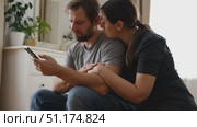 Loving mature couple using mobile phone. Husband and wife hugging, holding hands and looking at the smartphone screen. Man and woman share content on social media app. Young people watch the cellphone. Стоковое видео, видеограф Марина Демидюк / Фотобанк Лори