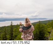 Девушка в камуфляже  смотрит на реку с вершины таёжной сопки. Стоковое фото, фотограф Роман Аксёнов / Фотобанк Лори