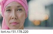 This woman wears a pink headscarf while confidently standing outside, reflecting her strength during her cancer journey. Стоковое AI-видео, аниматор Данила Большаков / Фотобанк Лори
