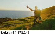 Two hikers celebrate the stunning sunset over the ocean while exploring a scenic coastal trail. Стоковое AI-видео, аниматор Данила Большаков / Фотобанк Лори