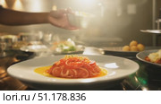 A talented chef skillfully plates a vibrant pasta dish while surrounded by an elegant kitchen atmosphere and culinary tools. Стоковое AI-видео, аниматор Данила Большаков / Фотобанк Лори