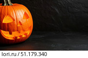 Halloween pumpkin on black background with space for text. Стоковое AI-изображение, AI-художник Ирина Самойлова / Фотобанк Лори