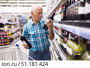 mature senor choosing alcoholic drinks in supermarket. Стоковое фото, фотограф Татьяна Яцевич / Фотобанк Лори