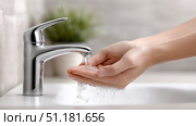 Washing hands at a modern sink with a sleek faucet in a bathroom setting. Стоковое AI-изображение, AI-художник Katsiaryna Repich / Фотобанк Лори