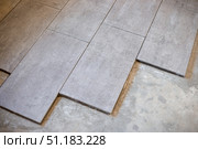 Close-up of large format ceramic tiles being laid on cement screed. Стоковое фото, фотограф Коханова Наталья / Фотобанк Лори