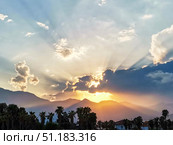 Majestic sunset over mountains with dramatic clouds and rays of sunlight illuminating landscape. Стоковое фото, фотограф Наталья Семкина / Фотобанк Лори