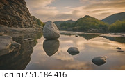 Rock precariously balanced on top of body of water, showcasing forces of nature at play. Rock remains still as ripples flow around it, creating dynamic and fascinating scene. Стоковое AI-видео, аниматор Данила Большаков / Фотобанк Лори