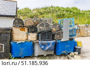 Stacked lobster pots, crab traps and blue fish crates at a coastal fishing yard. Стоковое фото, фотограф Zydrius Tartenis / Фотобанк Лори