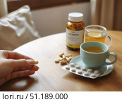 Человек принимает таблетки и пьёт чай с лимоном / A person takes pills and drinks tea with lemon. Стоковое AI-изображение, AI-художник Валерий Лукин / Фотобанк Лори