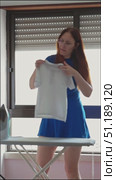 Housewife inspecting child's t shirt before ironing. Стоковое видео, видеограф Константин Шишкин / Фотобанк Лори