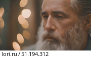 Old man with a long white beard is standing outside, staring into the distance. He is wearing worn-out coat. Mans beard reaches chest and wrinkled face shows signs of age and wisdom. Стоковое AI-видео, аниматор Данила Большаков / Фотобанк Лори