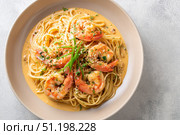 Shrimp Scampi. Spaghetti with shrimp and Creamy Garlic White Wine Sauce on a plate, top view. Scrumptious shrimp and fettuccine pasta with a cilantro, copy space. Linguine Alfredo. Italian cuisine. Стоковое AI-изображение, AI-художник Марина Демидюк / Фотобанк Лори