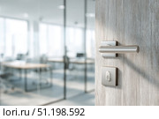 Doorknob. Metal door handle lock and latch of brass on veneer doors. Door wooden half opening through interior bedroom background, selective focus. Modern trends in interior design. Close-up. Стоковое фото, фотограф Марина Демидюк / Фотобанк Лори