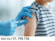 Child receiving a vaccination. Little boy in face mask in doctor's office is vaccinated. Kid giving injection shot. Syringe with covid-19, coronavirus, flu vaccine. Dangerous infectious disease, MPOX. Стоковое AI-изображение, AI-художник Марина Демидюк / Фотобанк Лори