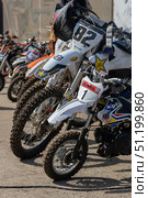 Magnitogorsk, Russian Federation - August 23, 2025: Enduro motorcycles lined up in a row, showcasing various brands and designs, ready for competition at an outdoor event with vibrant atmosphere. Редакционное фото, фотограф Ирина Ручушкина / Фотобанк Лори