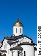 Magnitogorsk, Russian Federation - August 24, 2025: Church of the Intercession of the Most Holy Theotokos with golden dome under clear blue sky, showcasing architectural beauty and spiritual significance. Редакционное фото, фотограф Ирина Ручушкина / Фотобанк Лори