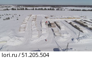 aerial photography of unloading logs from a car trailer using a manipulator and storing logs in an open area in winter. Стоковое видео, видеограф Алексей Сергеев / Фотобанк Лори